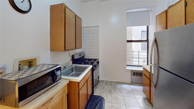 206 W 121st St Unit C, New York Manhattan, NY 10027 - kitchen with appliances with stainless steel finishes, light countertops, a sink, light tile patterned floors, and baseboards