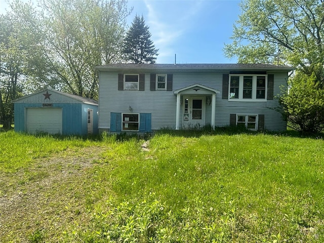 view of front of home with a garage and an outbuilding