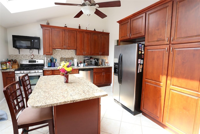 4 Rosemont Dr, New City, NY 10956 - kitchen featuring appliances with stainless steel finishes, light tile patterned flooring, a breakfast bar, ceiling fan, and tasteful backsplash
