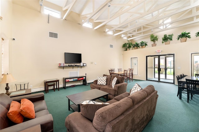 carpeted living room featuring a high ceiling, a baseboard heating unit, and baseboards