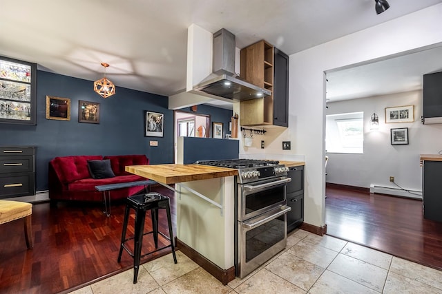 3 Hilltop Rd, Poughkeepsie, NY 12601 - kitchen featuring double oven range, wall chimney range hood, wooden counters, baseboard heating, and a breakfast bar