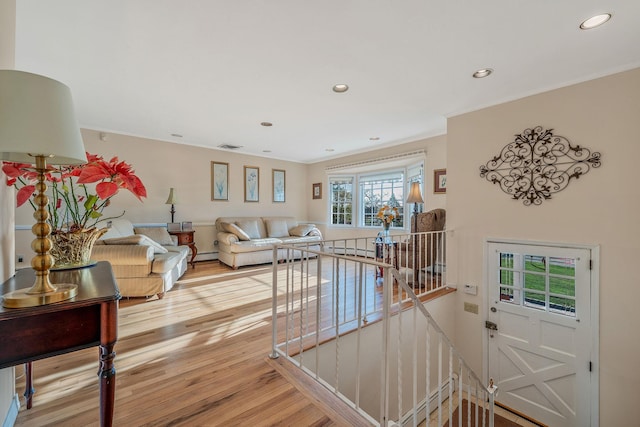 146 Awixa Ave, Bay Shore, NY 11706 - living room with light wood finished floors, a baseboard heating unit, recessed lighting, and ornamental molding
