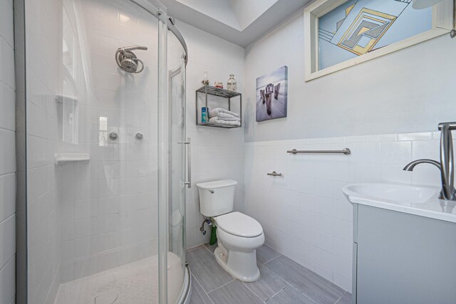 146 Awixa Ave, Bay Shore, NY 11706 - bathroom featuring a stall shower, toilet, tile walls, vanity, and a wainscoted wall