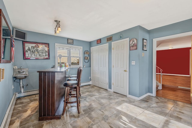 146 Awixa Ave, Bay Shore, NY 11706 - indoor dry bar featuring a baseboard radiator, stairs, and baseboards