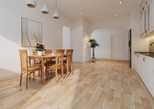 146 Awixa Ave, Bay Shore, NY 11706 - dining space featuring light wood-style floors, arched walkways, and crown molding