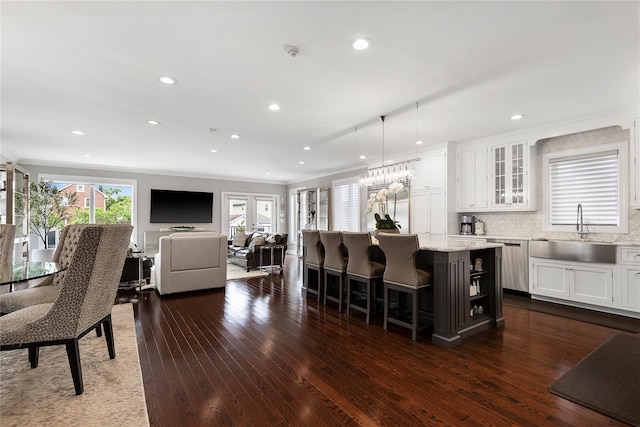 kitchen featuring a sink, dishwasher, white cabinets, dark wood finished floors, and a center island