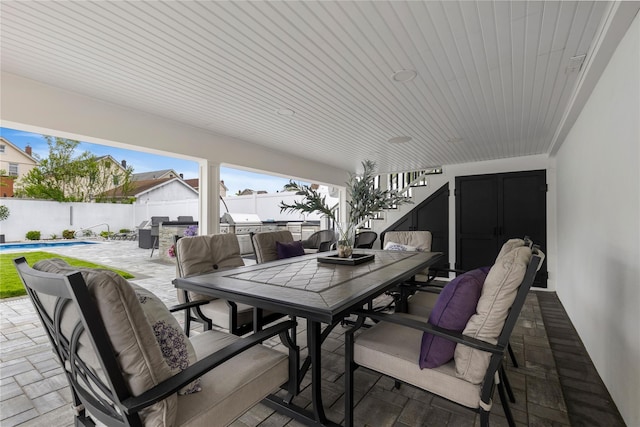 view of patio with outdoor dining space, stairway, and a fenced backyard