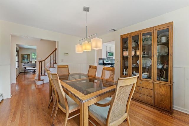 50 Burnside Dr, Hastings-On-Hudson, NY 10706 - dining room with wainscoting, light wood-type flooring, and stairway