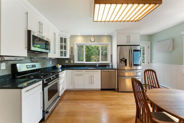 50 Burnside Dr, Hastings-On-Hudson, NY 10706 - kitchen featuring stainless steel appliances, glass insert cabinets, tasteful backsplash, white cabinets, and light wood-style floors