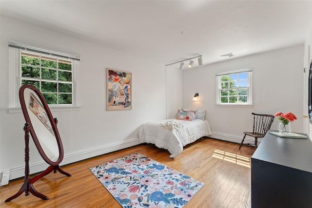 50 Burnside Dr, Hastings-On-Hudson, NY 10706 - bedroom featuring a baseboard radiator, light wood-style floors, and rail lighting