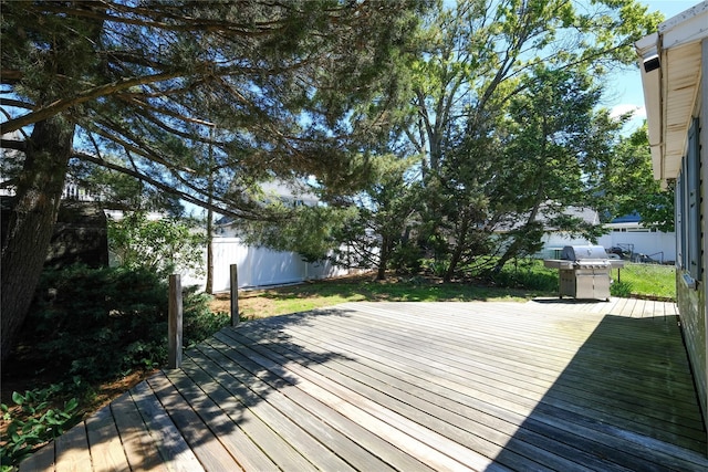 wooden terrace featuring a fenced backyard and a grill