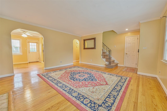 1652 Baker Ave, Merrick, NY 11566 - foyer entrance with arched walkways, light wood-style floors, stairs, baseboards, and ornamental molding
