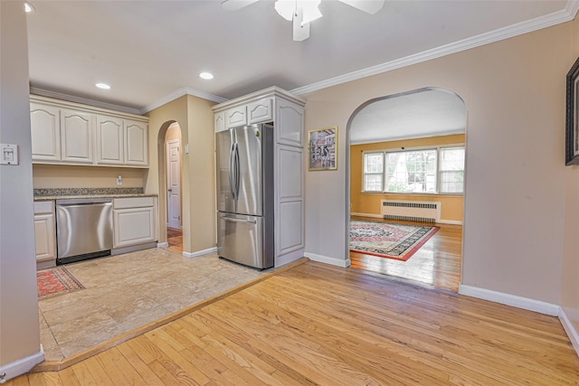 1652 Baker Ave, Merrick, NY 11566 - kitchen featuring arched walkways, appliances with stainless steel finishes, radiator heating unit, light wood-style floors, and crown molding