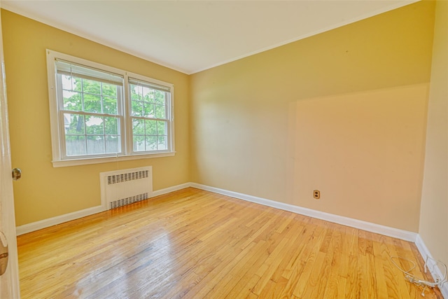 1652 Baker Ave, Merrick, NY 11566 - unfurnished room featuring radiator heating unit, hardwood / wood-style flooring, baseboards, and crown molding