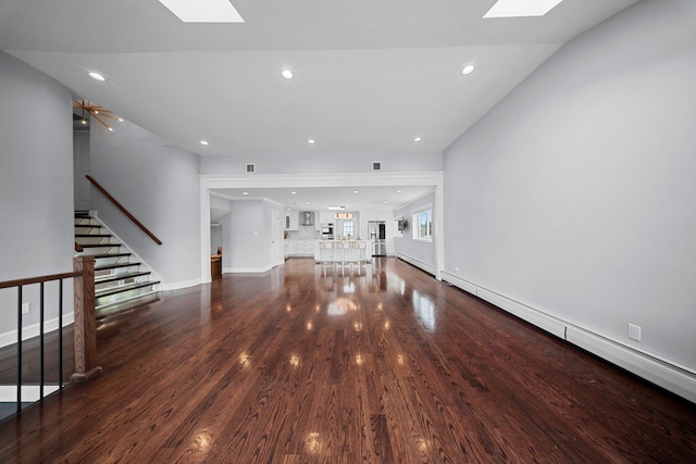 3161 Grand Ave, Baldwin Harbor, NY 11510 - unfurnished living room featuring a skylight, a baseboard radiator, stairway, wood finished floors, and recessed lighting