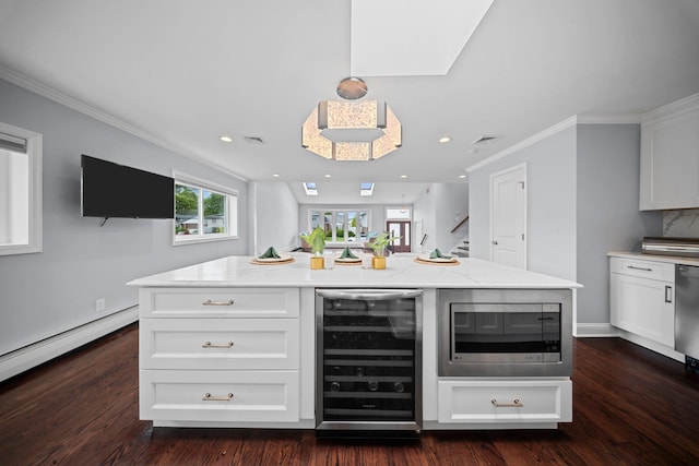 3161 Grand Ave, Baldwin Harbor, NY 11510 - kitchen with beverage cooler, stainless steel microwave, white cabinets, ornamental molding, and light stone counters