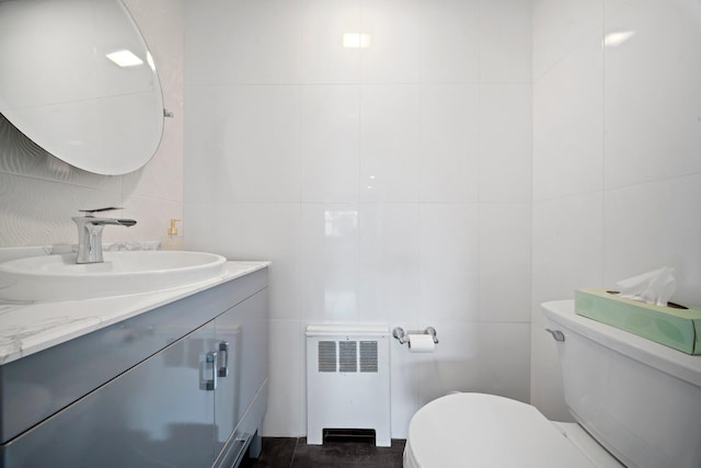 3161 Grand Ave, Baldwin Harbor, NY 11510 - bathroom with radiator heating unit, tile walls, toilet, and vanity
