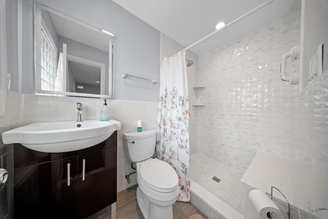 3161 Grand Ave, Baldwin Harbor, NY 11510 - full bathroom featuring tile walls, toilet, tiled shower, vanity, and a wainscoted wall