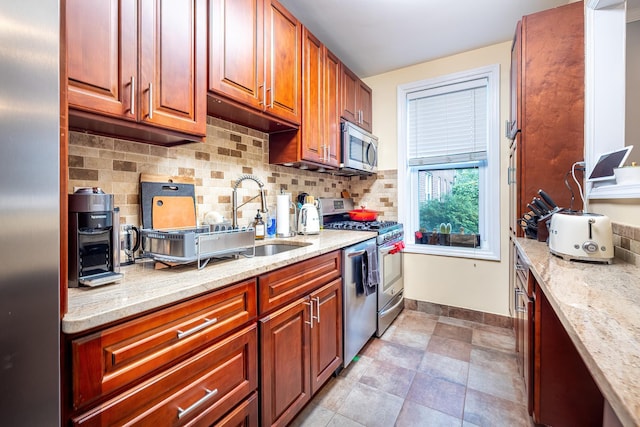 101 Old Mamaroneck Rd Unit 1B1, White Plains, NY 10605 - kitchen featuring appliances with stainless steel finishes, decorative backsplash, light stone countertops, and a sink