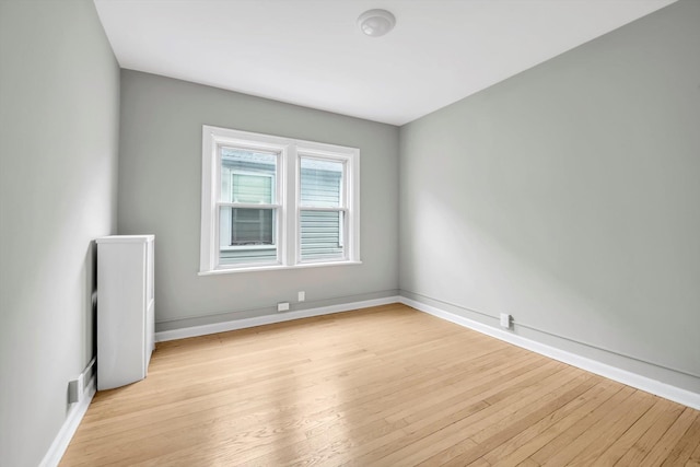 spare room with light wood finished floors and baseboards