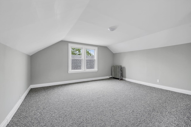 bonus room featuring radiator, carpet flooring, vaulted ceiling, and baseboards