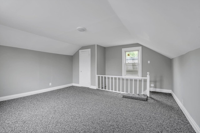 additional living space with carpet, vaulted ceiling, and baseboards