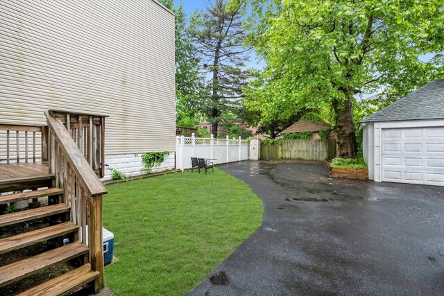 view of yard with an outdoor structure and asphalt driveway