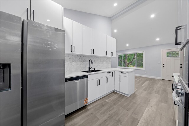 545 Granny Rd, Medford, NY 11763 - kitchen featuring stainless steel appliances, a sink, light countertops, light wood-type flooring, and decorative backsplash