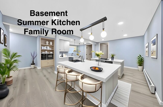 545 Granny Rd, Medford, NY 11763 - kitchen with a baseboard heating unit, light wood-style floors, a kitchen island with sink, baseboards, and recessed lighting
