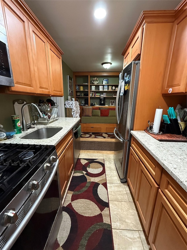 505 E Lincoln Ave Unit E302, Mount Vernon, NY 10552 - kitchen featuring appliances with stainless steel finishes, a sink, light stone countertops, and brown cabinets