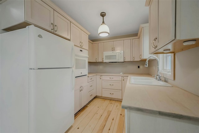 11 The Pkwy, Southampton, NY 11968 - kitchen featuring white appliances, a sink, light wood finished floors, light countertops, and decorative light fixtures