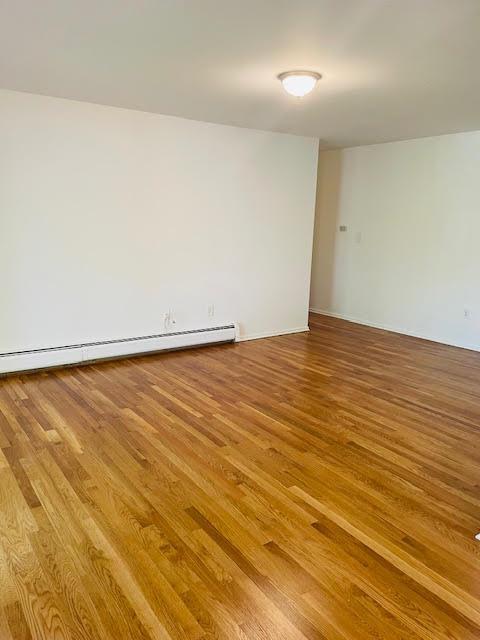 82 Demarest Ave Unit 15, West Nyack, NY 10994 - spare room with wood finished floors and a baseboard radiator