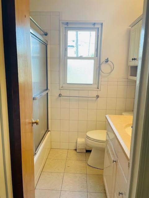 82 Demarest Ave Unit 15, West Nyack, NY 10994 - full bath with tile patterned flooring, tile walls, vanity, toilet, and enclosed tub / shower combo