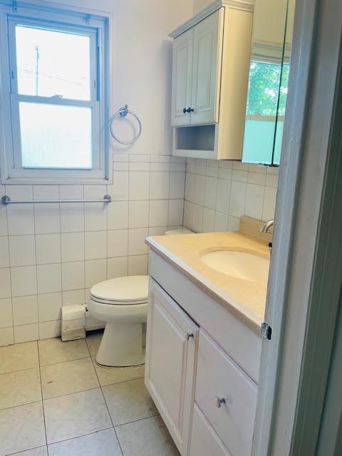 82 Demarest Ave Unit 15, West Nyack, NY 10994 - bathroom featuring tile walls, tile patterned floors, toilet, and vanity