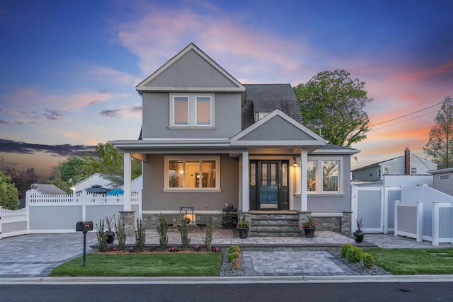 1 3rd Pl, Bellmore, NY 11710 - view of front of house featuring covered porch, stucco siding, fence, and a shingled roof