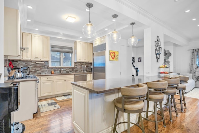 1 3rd Pl, Bellmore, NY 11710 - kitchen featuring appliances with stainless steel finishes, light wood-style flooring, a breakfast bar, tasteful backsplash, and recessed lighting