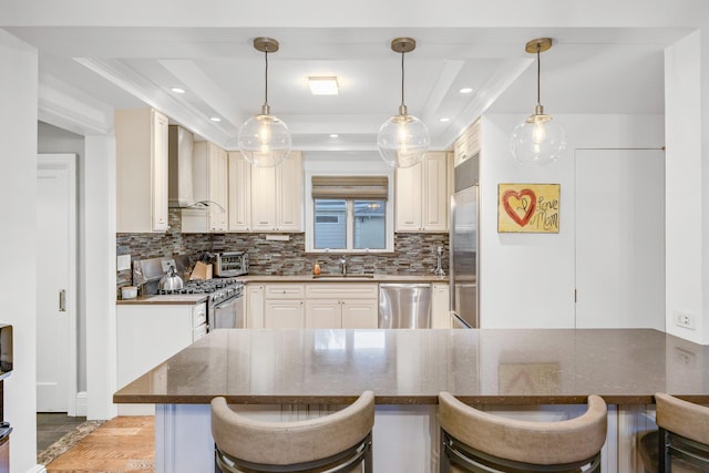 1 3rd Pl, Bellmore, NY 11710 - kitchen featuring stainless steel appliances, wall chimney exhaust hood, a sink, a raised ceiling, and backsplash