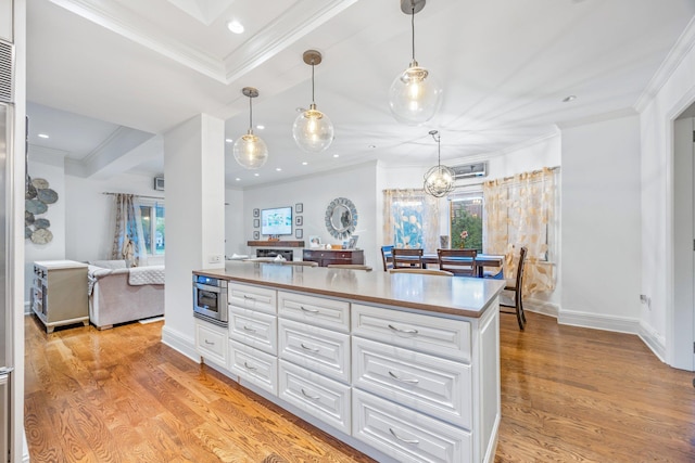 1 3rd Pl, Bellmore, NY 11710 - kitchen featuring white cabinetry, healthy amount of natural light, ornamental molding, light wood-style floors, and light countertops