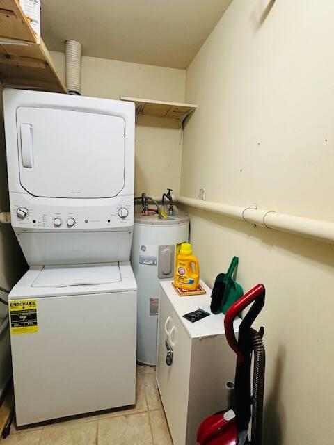 76 Highlands Dr Unit C2, Hunter, NY 12442 - laundry area featuring water heater, stacked washer / drying machine, and light tile patterned floors