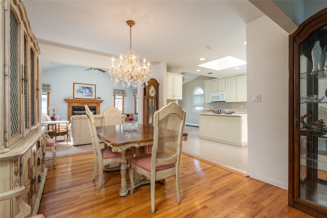 745 Willow Rd, Franklin Square, NY 11010 - dining space with light wood-type flooring, a chandelier, a skylight, recessed lighting, and baseboards