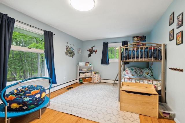 162 Forest Hill Dr, Kingston, NY 12401 - bedroom featuring wood finished floors, a baseboard radiator, and baseboard heating