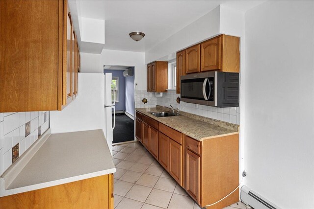 25-31/33 Francis Lewis Blvd, Whitestone, NY 11358 - kitchen with stainless steel microwave, a baseboard radiator, brown cabinetry, a sink, and backsplash