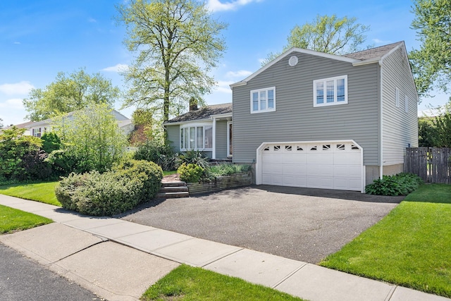 105 Farmers Ave, Plainview, NY 11803 - tri-level home featuring asphalt driveway, an attached garage, and fence
