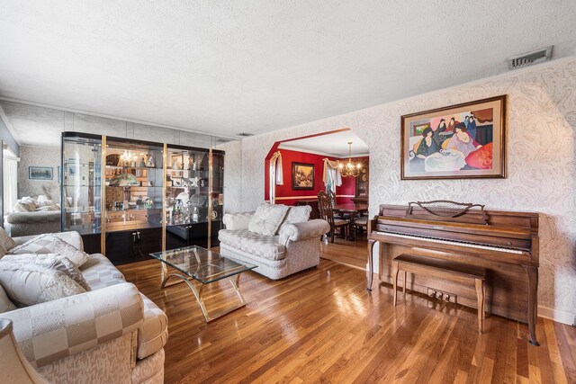 105 Farmers Ave, Plainview, NY 11803 - living area with wallpapered walls, wood finished floors, a textured ceiling, and a chandelier