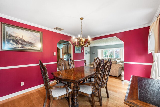 105 Farmers Ave, Plainview, NY 11803 - dining space featuring light wood finished floors, a chandelier, arched walkways, ornamental molding, and baseboards