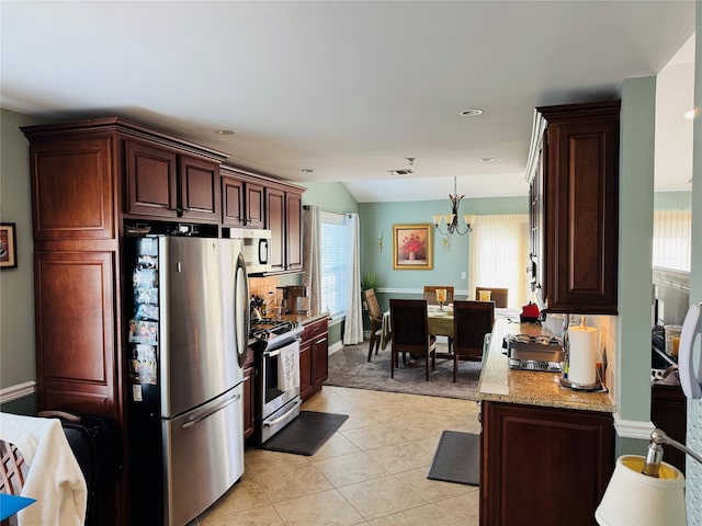 211 Pond Cir, Mount Sinai, NY 11766 - kitchen with appliances with stainless steel finishes, a chandelier, light tile patterned floors, light stone counters, and decorative light fixtures