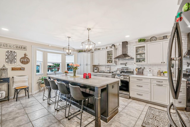 8 Emerald Ct, Moriches, NY 11955 - kitchen featuring wall chimney exhaust hood, stainless steel appliances, light countertops, backsplash, and a breakfast bar area