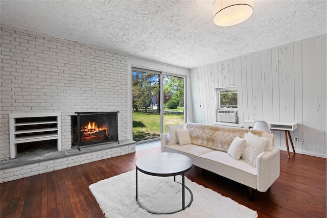 55 W End Ave, East Quogue, NY 11942 - living area featuring a textured ceiling, hardwood / wood-style floors, a fireplace, cooling unit, and wood walls