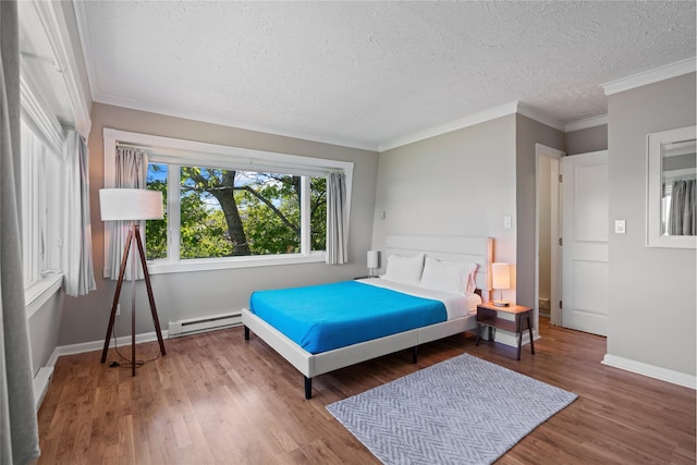 55 W End Ave, East Quogue, NY 11942 - bedroom featuring baseboard heating, a textured ceiling, wood finished floors, baseboards, and ornamental molding