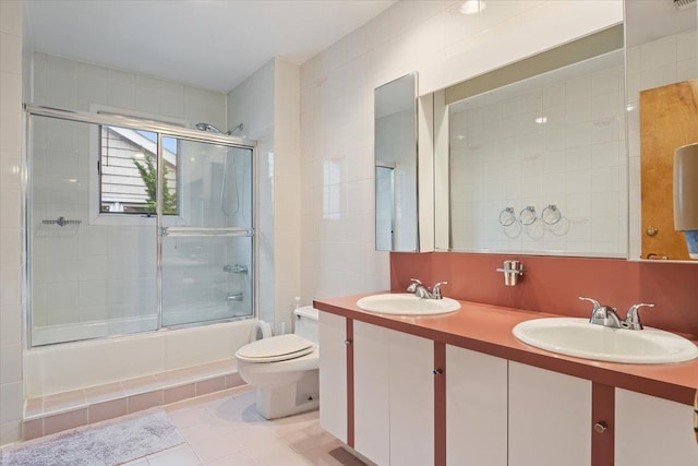 29 Sunset Rd S, Albertson, NY 11507 - bathroom featuring a sink, toilet, tile patterned flooring, and bath / shower combo with glass door